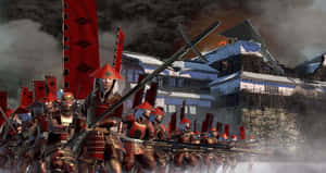 身穿紅色盔甲的武士戰士在戰鬥中前進，背景是燃燒的堡壘。 — 混沌武士 壁紙