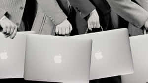 商務專業人士在單色照片中手持Apple筆記型電腦。 — 筆電 壁紙