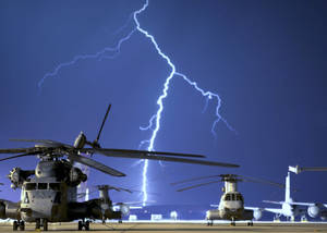 夜間雷暴下停泊在機場的直升機。 — 軍事動圖 壁紙