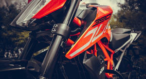一輛鮮橙色KTM 390越野機車帶有黑色點綴，停放在森林中。 — 改裝摩托車 壁紙