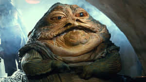 Jabba the Hutt，一個皮膚皺紋、眼睛發光的大型外星人，自鳴得意地坐著。 — 天行者崛起 壁紙