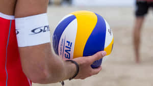 運動員在沙上手持官方FIVB沙灘排球。 — 排球 壁紙