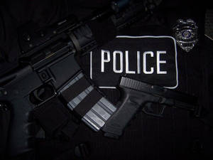 警察步槍手槍和徽章放在帶有警察補丁的制服上。 — 黑色高畫質桌布 壁紙