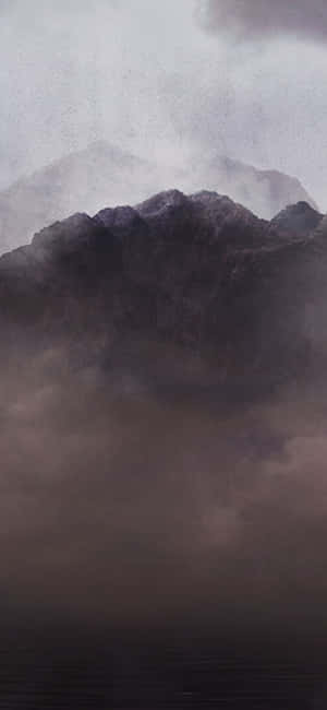 迷霧山巒在陰天之下升起於黑暗水域之上。 — Pixel 8 壁紙