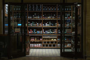 打開的玻璃門揭示了一家啤酒商店，裡面有裝滿瓶子和罐子的貨架。 — 桌面 壁紙