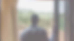 模糊人影站在門口望向外面綠色。 — 背景 壁紙