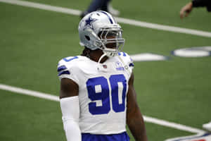 達拉斯牛仔隊球員90號在足球場上戴著頭盔和制服。 — 運動 壁紙