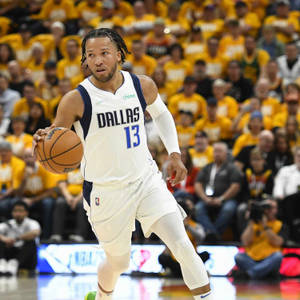 達拉斯獨行俠籃球運動員在比賽中運球，球迷身穿黃色球衣。 — 運動 壁紙