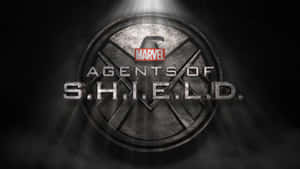 在黑暗煙霧背景的聚光燈下，帶有Marvel品牌的S.H.I.E.L.D.標誌 — 1600x900 壁紙