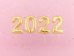 金色2022氣球與五彩紙屑在粉紅色背景上 — 氣球 壁紙