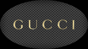 金色Gucci標誌在黑色字母圖案背景上。