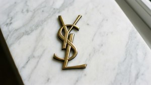 白色大理石表面上的金色YSL標誌 — YSL 壁紙