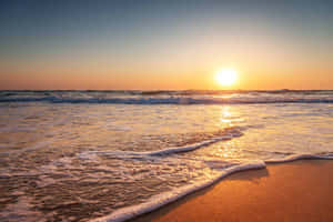 夕陽海浪沖刷著海邊溫暖的沙灘。 — 牙買加海灘 壁紙