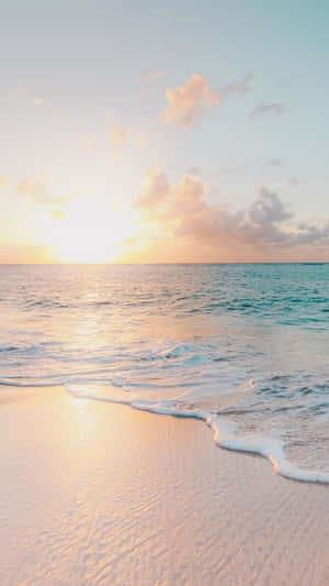 夕陽海浪沖刷粉紅沙灘，伴隨粉彩天空雲朵。 — 海灘度假 壁紙