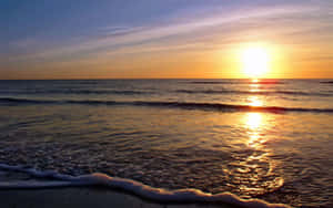 海上夕陽，溫柔的海浪滾滾湧上沙灘。 — 海灘日落 壁紙