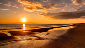 海上夕陽，濕沙上的波浪和金色雲朵 — 海灘桌面 壁紙
