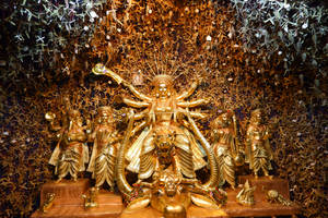 金色多臂多武器杜爾迦女神雕像，周圍環繞著摺紙鶴。 — Maa Durga 壁紙