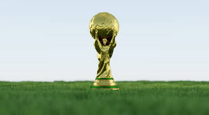 晴朗天空下綠色草地上的金色世界盃獎盃 — FIFA 世界盃 壁紙