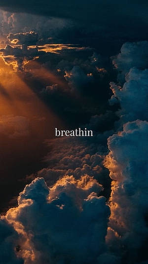 陽光穿過雲層，帶有文字 breathin