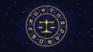 金色黃道輪盤，中央有天秤座天秤，周圍環繞星座，背景為繁星點點的夜空。 — 天秤座 壁紙