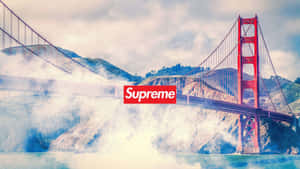 金門大橋上疊加紅色Supreme標誌，背景是霧氣瀰漫的水面和山丘。 — 塔橋 壁紙