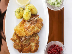 白色盤子上的酥脆炸肉排、馬鈴薯、檸檬和配菜。 — 薯條 壁紙