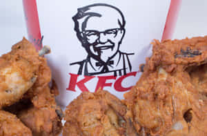 酥脆的炸雞塊從帶有桑德斯上校標誌的KFC桶中溢出。 — 肯德基 壁紙
