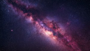 銀河系，帶有發光的粉紅色和紫色星雲以及無數的星星。