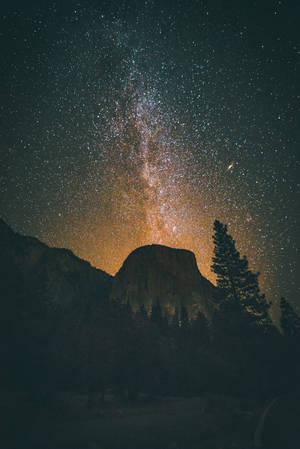 銀河系在夜間與星星和樹木一起拱起在酋長岩山上。 — 岩石 壁紙