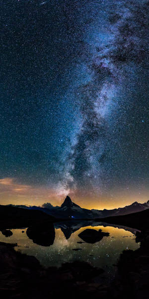 夜晚在山湖中倒映的銀河系。 — 自然 iPhone 壁紙
