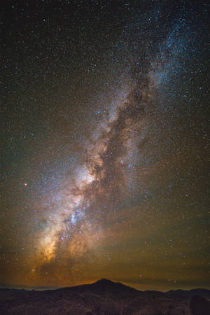 夜晚，銀河系在山脈上空發光。 — 星星 壁紙
