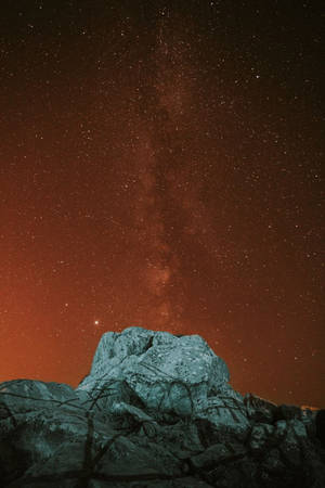在可見銀河的紅色星空下的岩石山。 — 星空動畫 壁紙