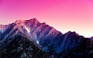 黃昏時分的粉紅色和紫色山脈，帶有雪斑和閃耀的天空。 — 山景 壁紙