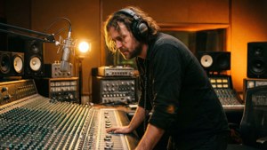 音樂家在錄音室中戴著耳機調整音頻混音台。 — 羅德·韋夫 壁紙