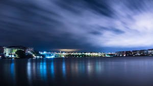 夜景城市景觀，橋樑燈光在水面上反射，天空有條紋雲。 — 城市 壁紙