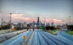 黃昏時分的高速公路，帶有汽車燈光軌跡和背景的城市天際線 — 芝加哥 壁紙