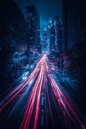 夜晚的城市街道，高樓之間有移動車輛的紅色和白色光條。 — 城市風景 壁紙