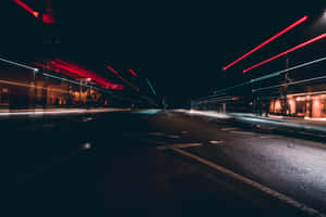 夜晚街道，有來自移動車輛的紅色和藍色光條紋。 — MacBook Air M3 壁紙