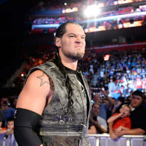 星星刺青的摔角手在競技場中凝視著歡呼的人群。 — WWE GIF 壁紙