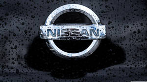日產汽車標誌被雨滴覆蓋在深色表面上。 — 日產 壁紙