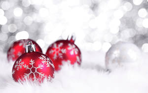 白色毛皮上的紅色雪花聖誕裝飾品，帶閃爍的銀色背景。 — 節日 GIF 壁紙