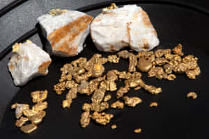 深色岩石表面上的金塊和金片 — 金色動態 壁紙