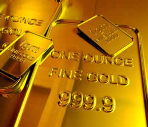 堆疊的金條標示為 one ounce fine gold 999.9，表面反光。 — 金色動態 壁紙