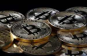 一堆金色比特幣，在深色背景上刻有符號。 — 比特幣 GIF 壁紙
