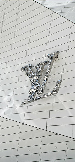 幾何圖案白色瓷磚牆上的鉻色 Louis Vuitton 標誌。