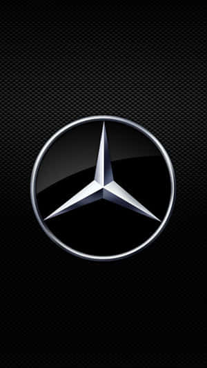 黑色碳纖維紋理上的閃亮 Mercedes-Benz 標誌。 — Mercedes-Benz 壁紙