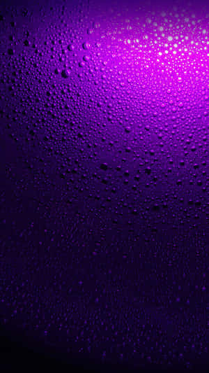 彎曲表面上的紫色水滴，上方有發光的光芒。 — 紫色 iPhone 壁紙