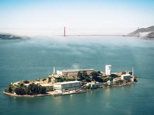 阿爾卡特拉斯島上的監獄建築和金門大橋，籠罩在霧氣中的海灣。 — 天空景色 壁紙