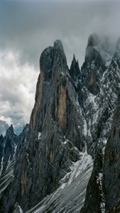 多雲天空下，高聳的積雪山峰。 — 山景 壁紙