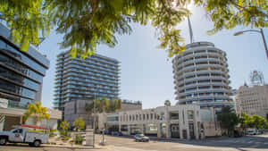 陽光普照的城市街道，有Capitol Records大樓和現代玻璃摩天大樓，被樹枝框住。 — 華盛頓首都隊 壁紙